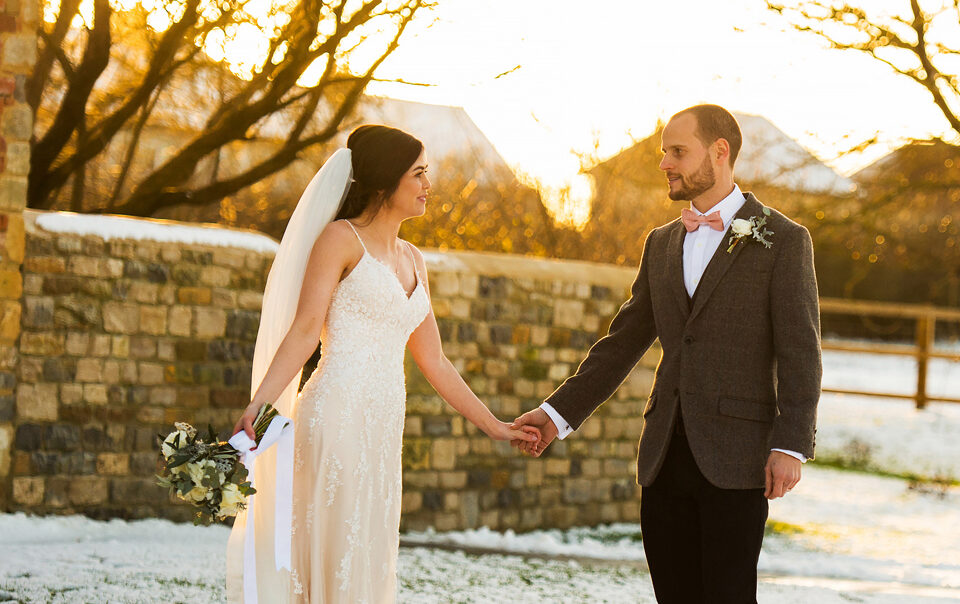 A couple stand in the snow at Blackwell Grange